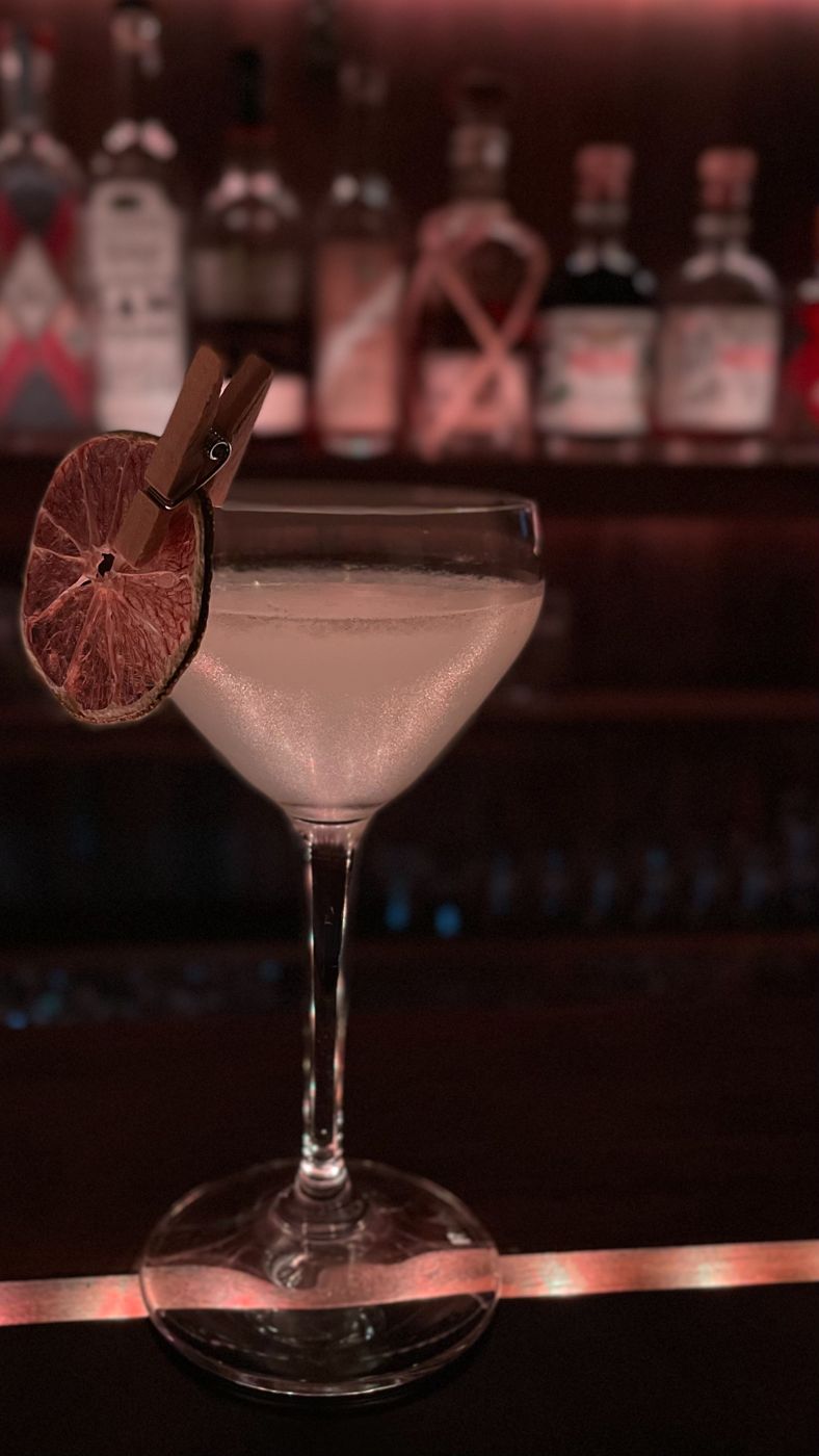A signature cocktail with a dried citrus slice clipped to the glass