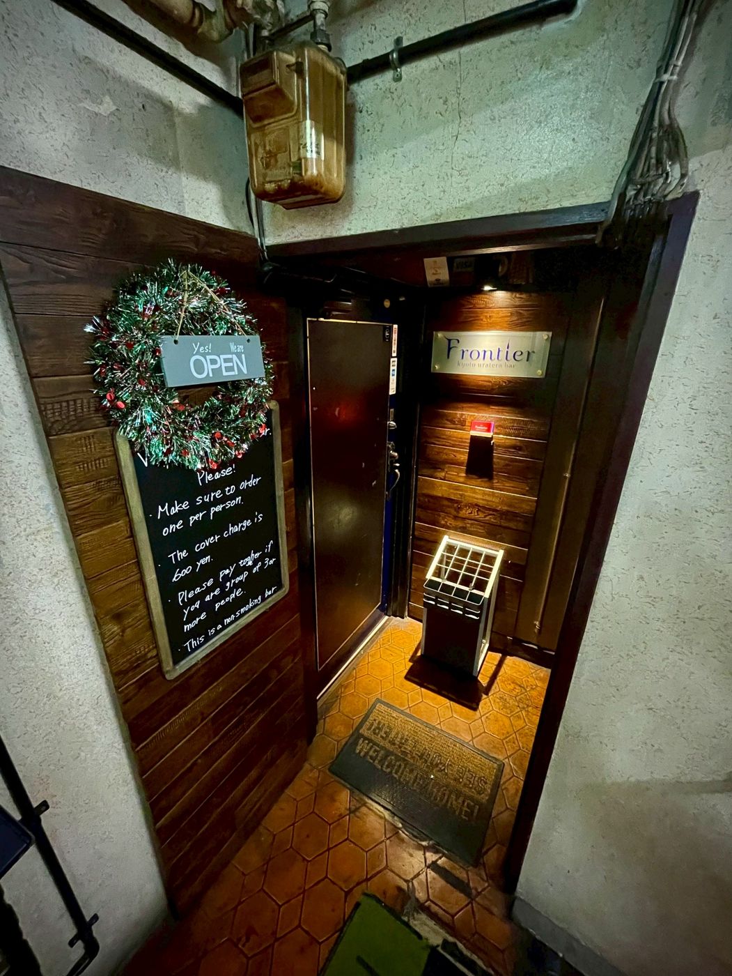 Frontier bar door on the 3rd floor with an open sign and a chalkboard of house rules